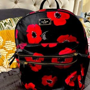 Kate Spade gently used nylon backpack in red poppy over black background.